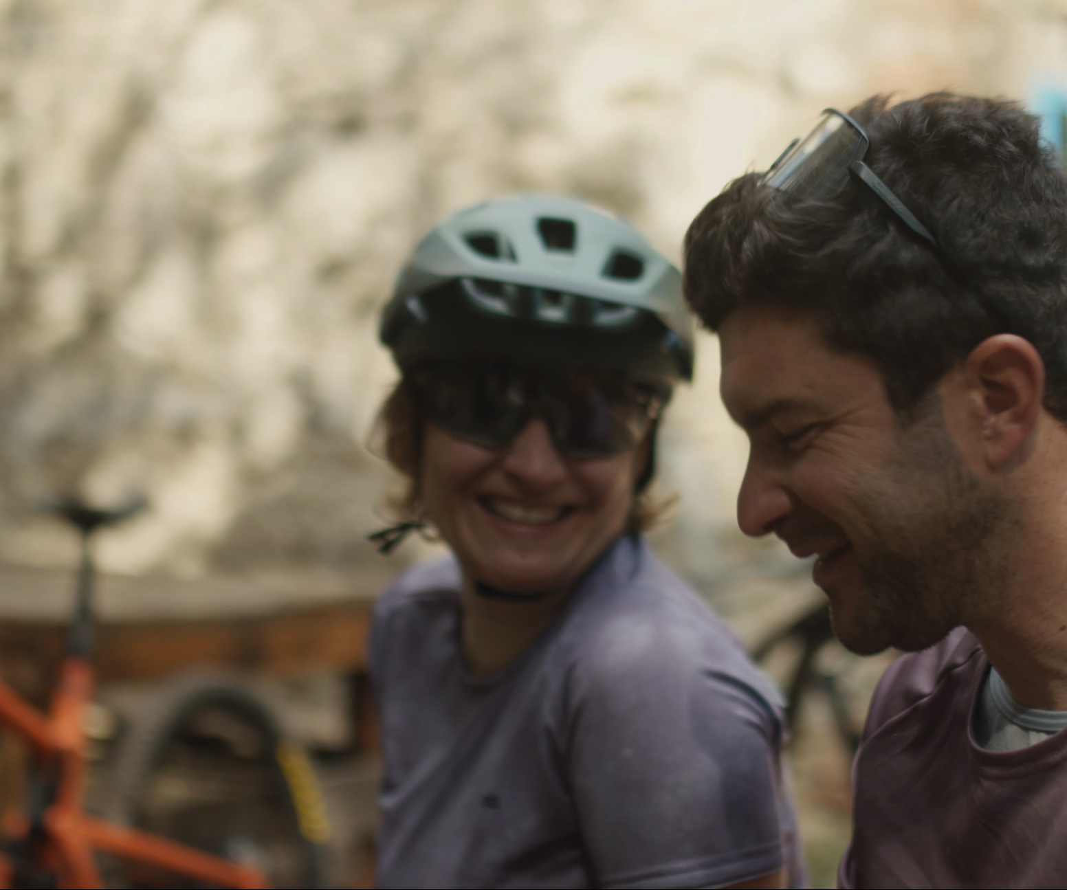 Two people smiling near mountain bikes, perfect for Mountain Bike Content Creation and showcasing Mountain Bike Event Planner activities. LOAM.