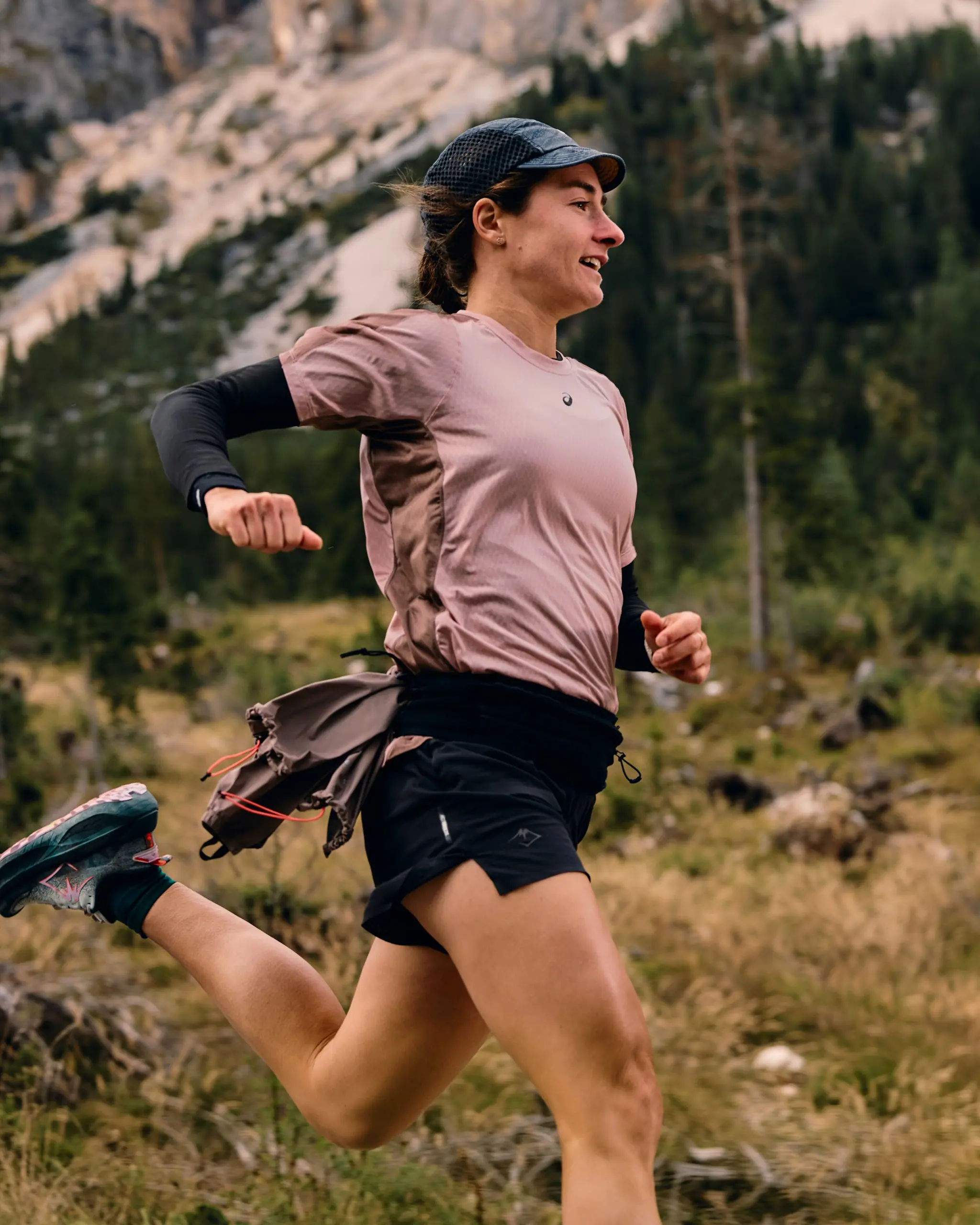 Woman running on a mountain trail, showcasing outdoor sports project logistical support and mountain bike marketing agency synergy. LOAM.