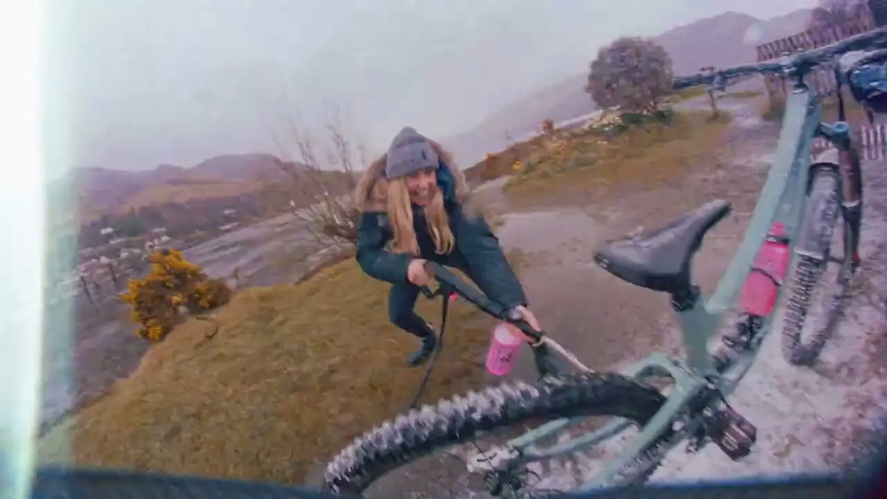 Mountain biker using Muc-Off Mobile Pressure Washer, supported by Mountain Bike Project Logistical Support, in scenic outdoor setting. LOAM.