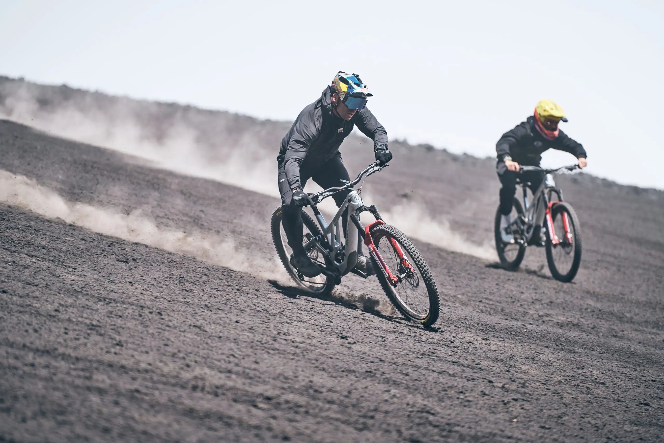 Mountain bikers on a trail, showcasing speed and skill at a Mountain Bike Press Camp. Ideal for Mountain Bike Marketing and Event Planning content. LOAM.
