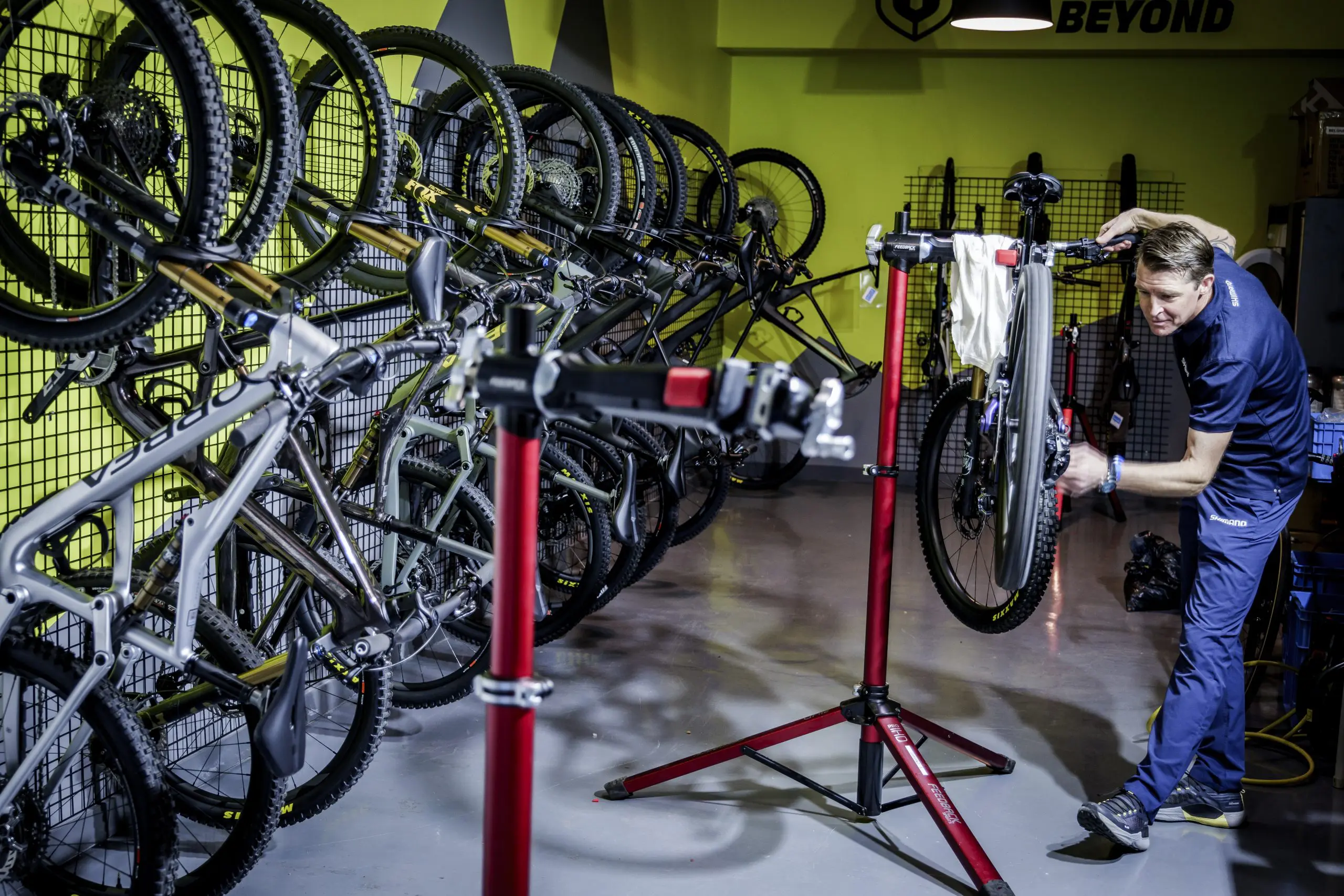 Man tuning mountain bike in workshop. Mountain Bike Press Camp planner and event support. Focus on Mountain Bike Marketing Agency and content creation. LOAM.