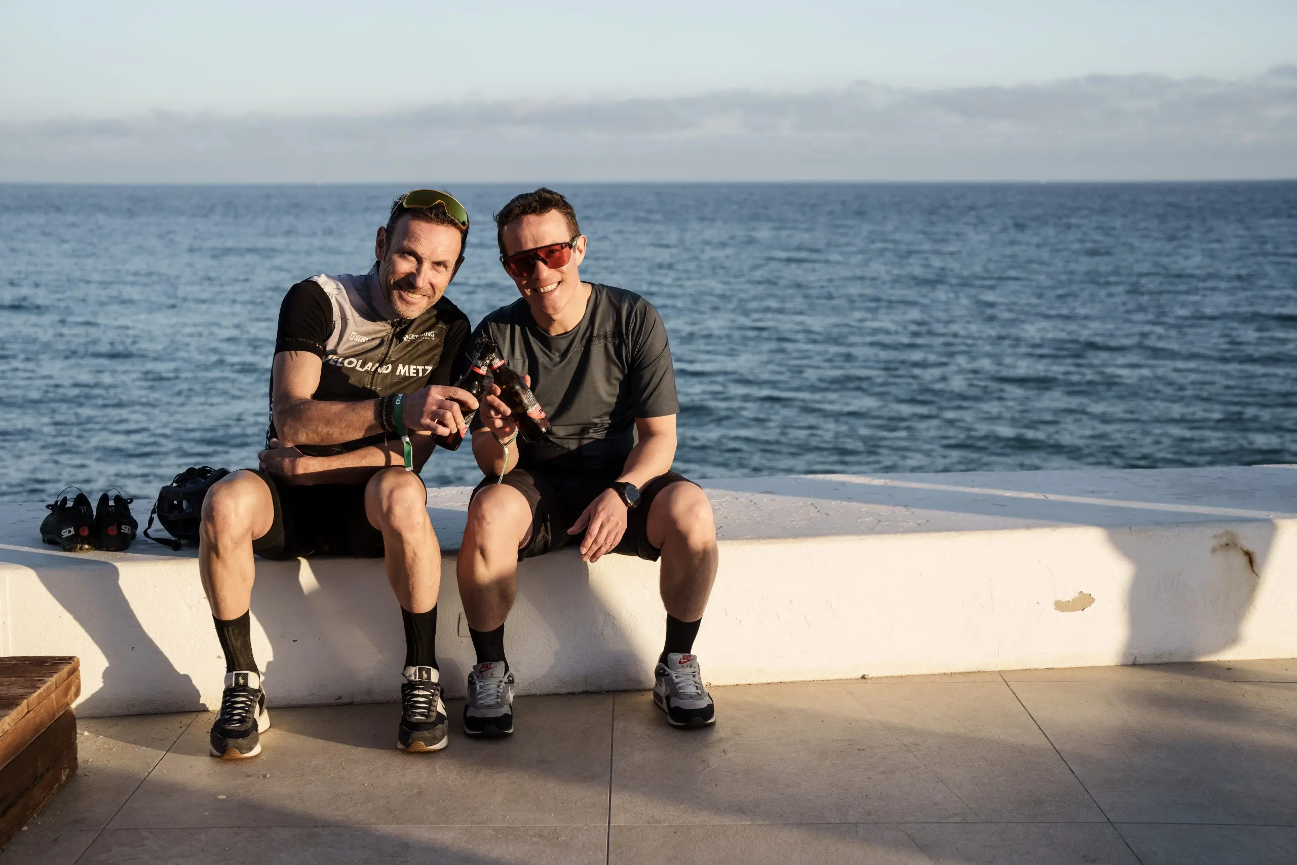 Two men enjoying a coastal view during a Mountain Bike Press Camp, highlighting Mountain Bike Marketing and Event Planning expertise. LOAM.