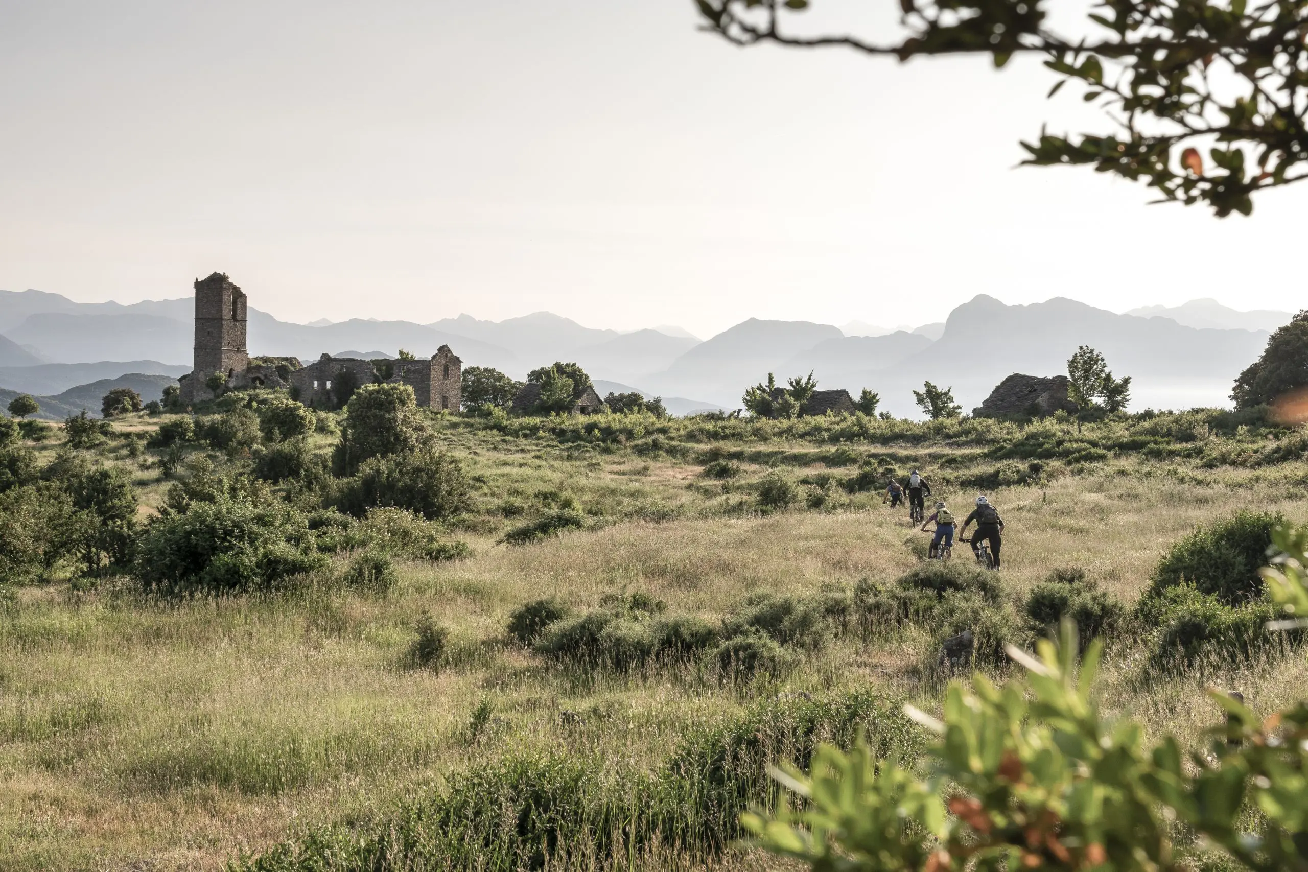 Cyclists at Mountain Bike Press Camp near ruins, showcasing Mountain Bike Marketing Agency strategies and content creation amidst scenic views. LOAM.